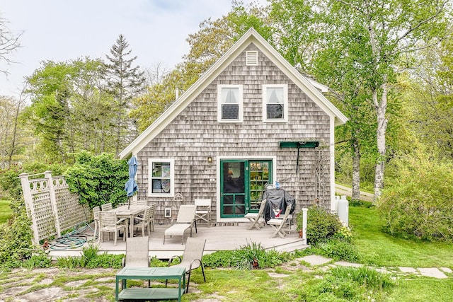 rear view of property with a wooden deck and a yard