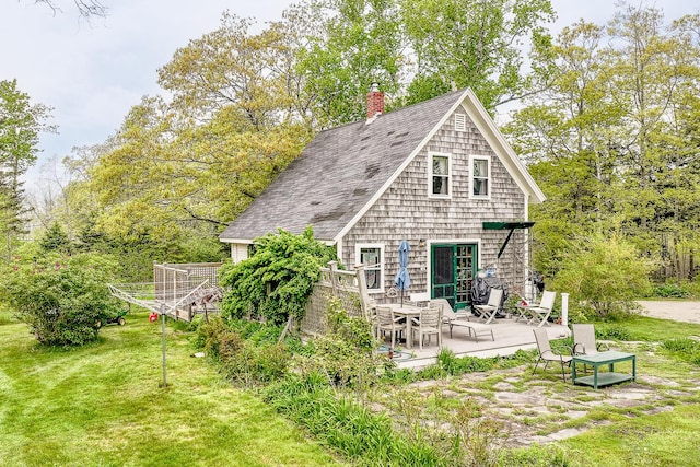 rear view of property with a yard and a patio