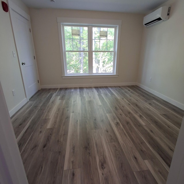 5 Apex Dr Unit 1, Westbrook, ME 04092 - empty room with a wall unit AC, wood finished floors, and baseboards