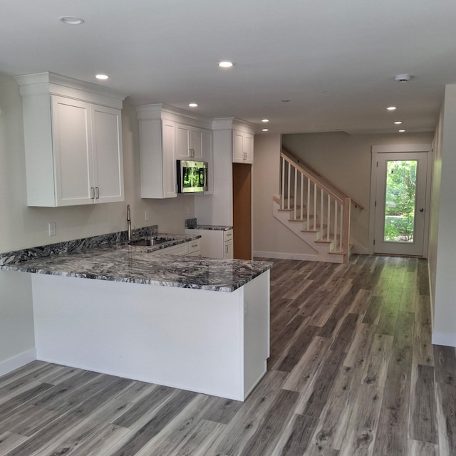 5 Apex Dr Unit 1, Westbrook, ME 04092 - kitchen with stainless steel microwave, dark stone countertops, wood finished floors, a sink, and white cabinetry