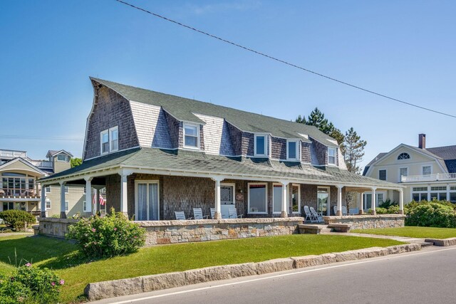 93 Beach Ave, Kennebunk, ME 04043 - shingle-style home featuring a gambrel roof, a porch, a front yard, and roof with shingles