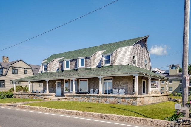 93 Beach Ave, Kennebunk, ME 04043 - view of front of house featuring a gambrel roof, covered porch, a shingled roof, and a front lawn