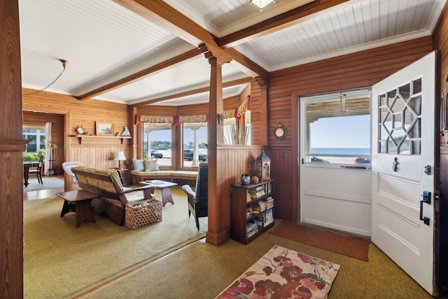 interior space featuring crown molding, light colored carpet, beamed ceiling, and wood walls