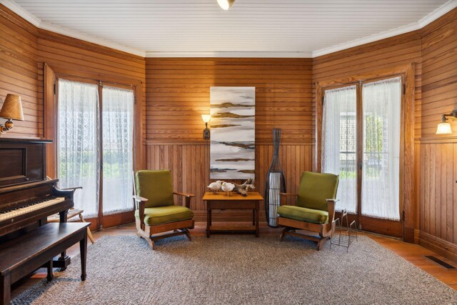 sitting room with wood-type flooring and wood walls