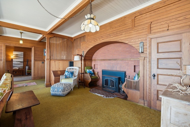 living area with carpet floors, a wood stove, beam ceiling, and wood walls