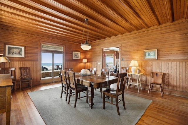 dining room featuring wood-type flooring and wooden ceiling