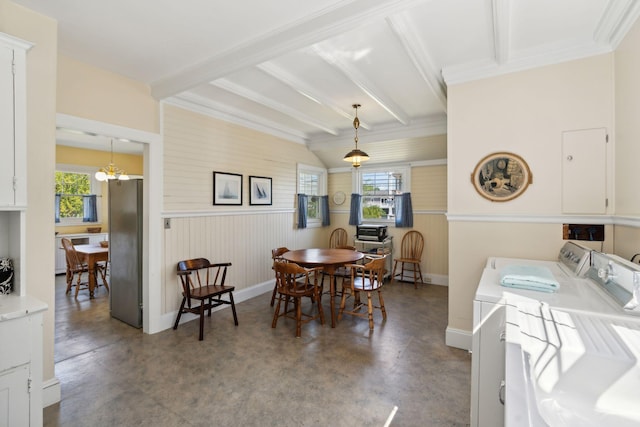 dining area featuring beamed ceiling, washing machine and clothes dryer, concrete floors, and a notable chandelier