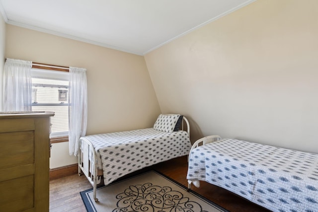 bedroom with hardwood / wood-style floors and ornamental molding