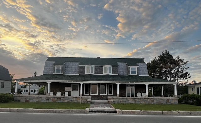 farmhouse inspired home featuring a yard and covered porch