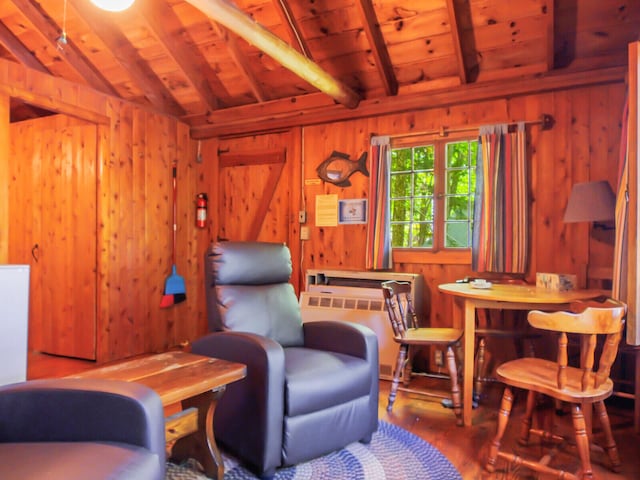 sitting room featuring wooden ceiling, vaulted ceiling with beams, and wood walls