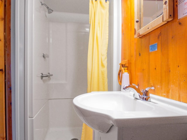 bathroom with wood walls and walk in shower