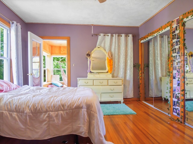 bedroom featuring ceiling fan, a closet, hardwood / wood-style flooring, and a textured ceiling