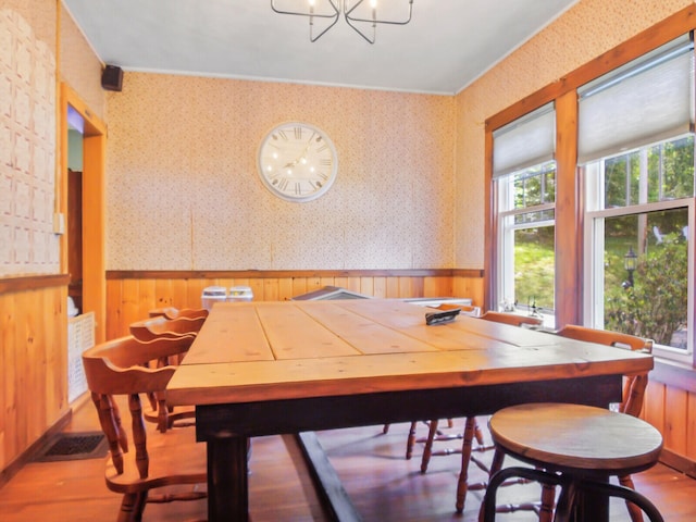 dining space with hardwood / wood-style flooring and an inviting chandelier