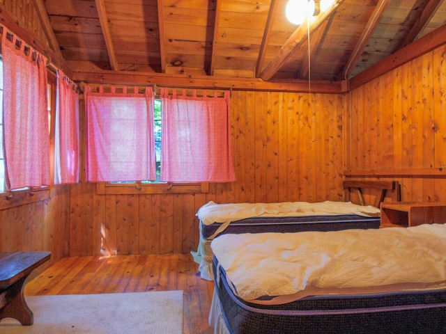 bedroom with vaulted ceiling with beams, hardwood / wood-style flooring, and wood ceiling