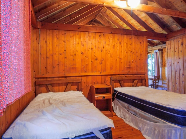 bedroom featuring wood ceiling, vaulted ceiling with beams, and wood walls