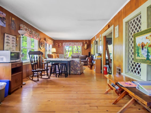 living room with wood walls and light hardwood / wood-style flooring