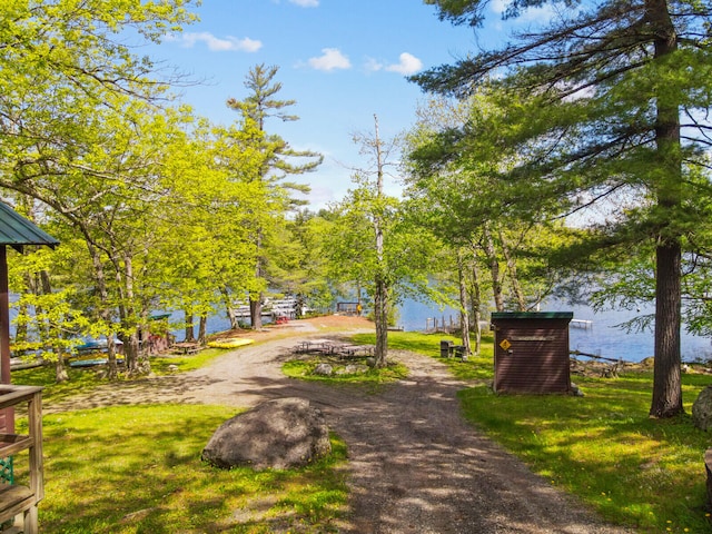 view of property's community with a water view and a yard