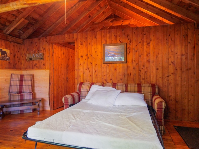 bedroom with vaulted ceiling with beams, wooden walls, wood-type flooring, and wood ceiling