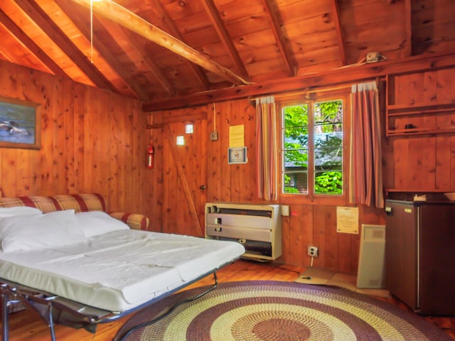 bedroom featuring lofted ceiling with beams, light hardwood / wood-style floors, wood walls, and wooden ceiling