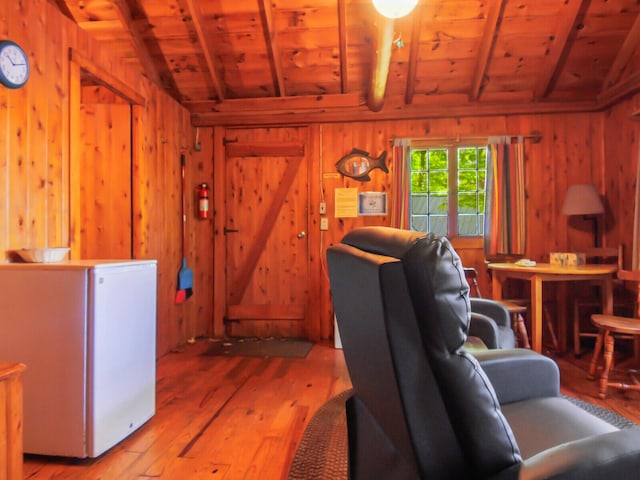 living room with wooden ceiling, hardwood / wood-style flooring, lofted ceiling with beams, and wooden walls