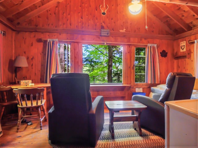 living room with wooden walls, hardwood / wood-style flooring, and lofted ceiling