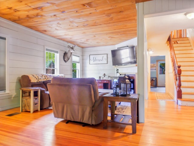 living room with light hardwood / wood-style flooring and wood ceiling