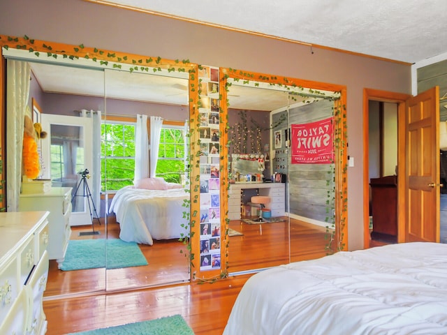 bedroom featuring hardwood / wood-style flooring, a textured ceiling, and crown molding