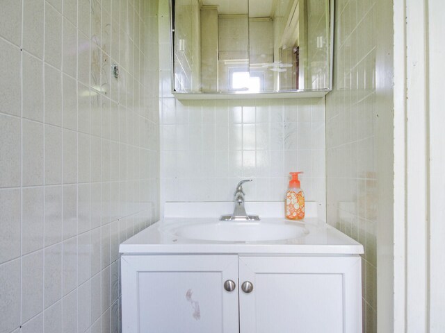 bathroom featuring tile walls and vanity