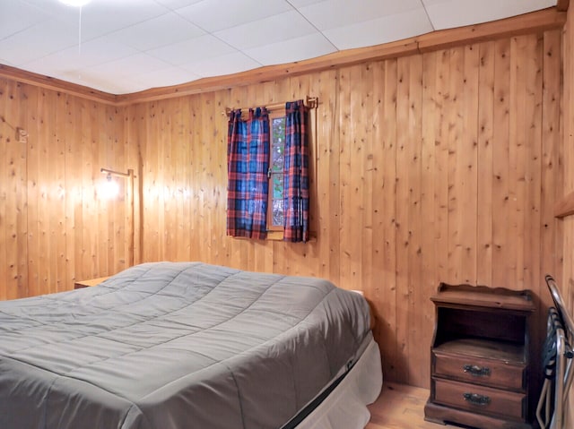 bedroom with wood walls and hardwood / wood-style floors