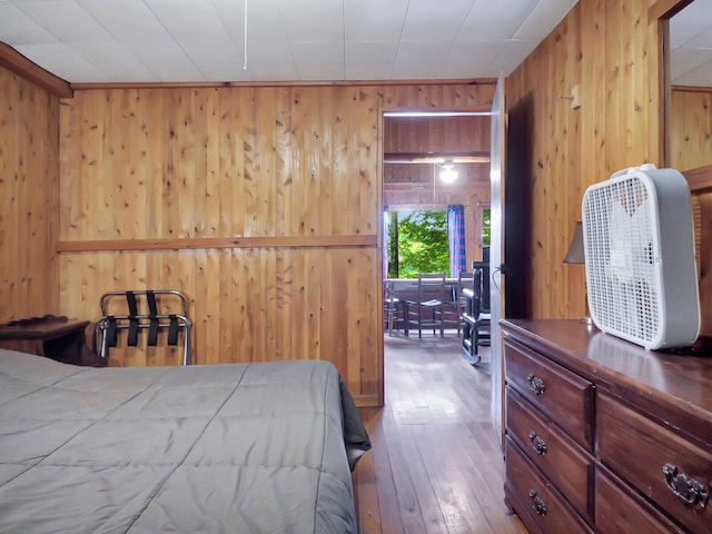 bedroom featuring hardwood / wood-style flooring and wood walls