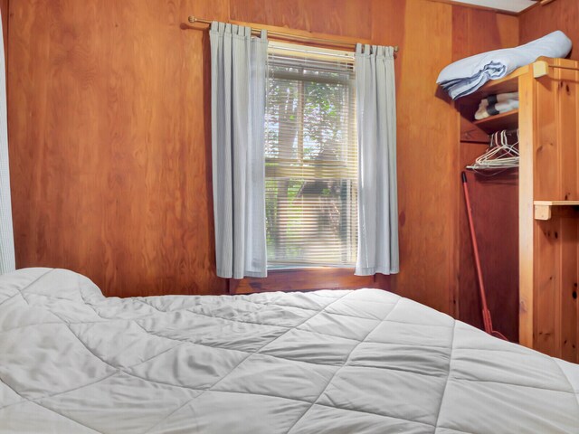 bedroom featuring wooden walls and a closet