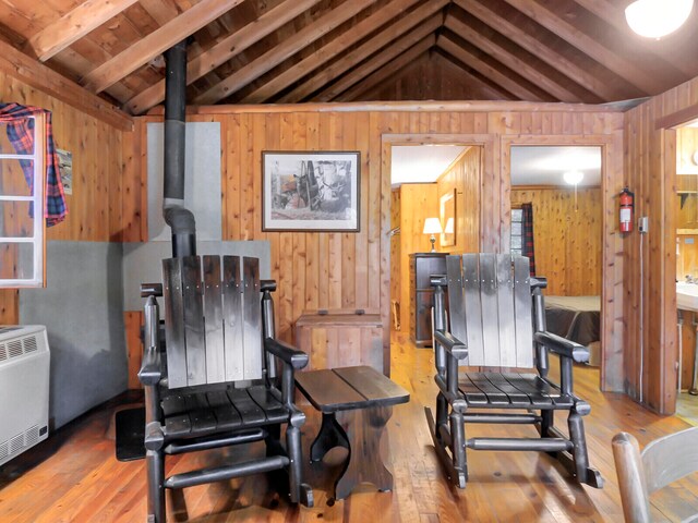 interior space with wooden walls, radiator heating unit, light hardwood / wood-style flooring, and lofted ceiling