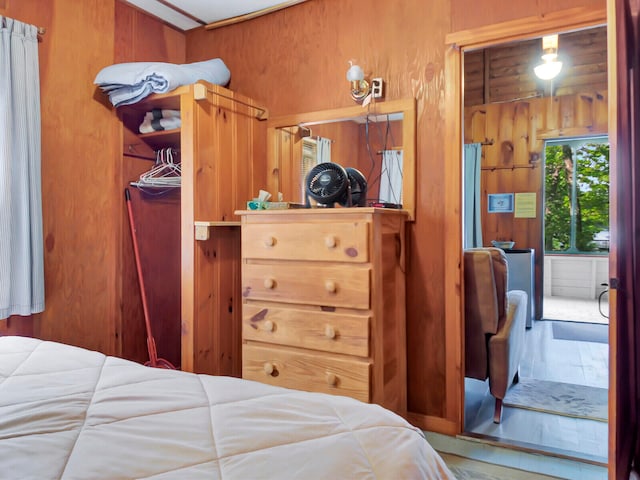 bedroom featuring wood walls and hardwood / wood-style floors