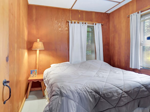 bedroom featuring wooden walls