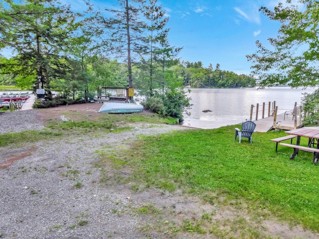 view of yard featuring a water view and a dock