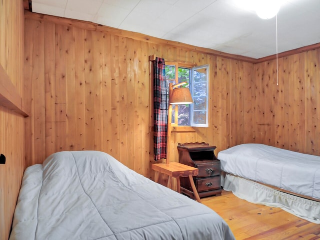 bedroom with wooden walls and hardwood / wood-style floors