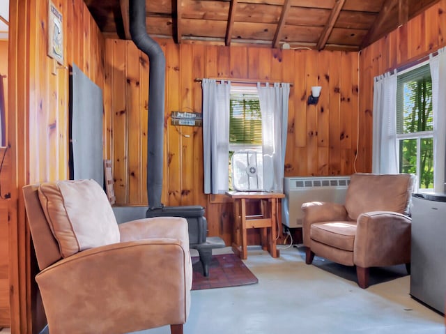 sitting room featuring lofted ceiling, wood ceiling, radiator, and wood walls