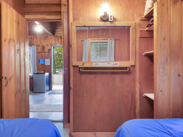 bedroom with wood walls and hardwood / wood-style floors