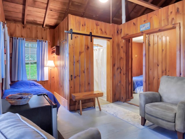 bedroom featuring a barn door, wood ceiling, and wood walls