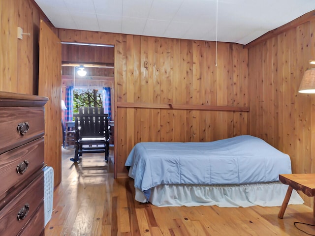 bedroom featuring wood walls and wood-type flooring