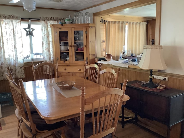 dining space with hardwood / wood-style floors and ornamental molding