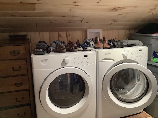 clothes washing area featuring wood walls, washer and clothes dryer, and wooden ceiling