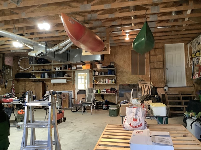 miscellaneous room featuring concrete flooring and wooden walls