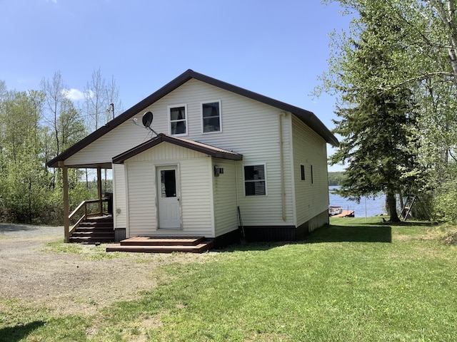 rear view of property featuring a lawn