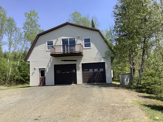 view of front of property featuring a balcony and a garage