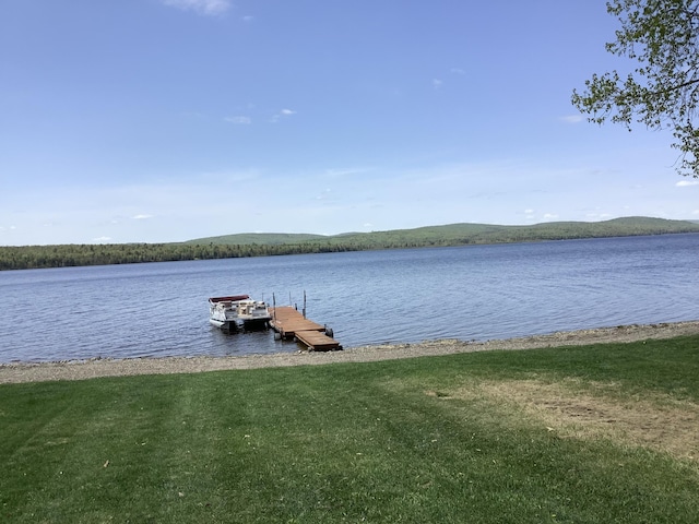 view of dock with a yard and a water and mountain view