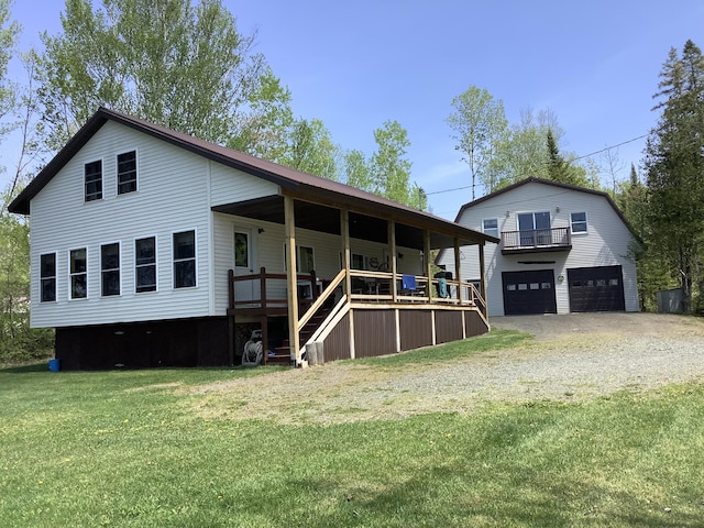 back of house with a yard, covered porch, and a garage