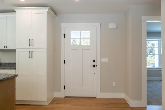 entryway with light wood-type flooring and baseboards