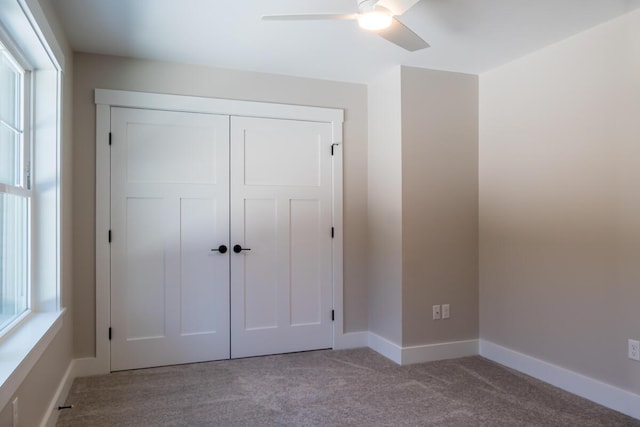 unfurnished bedroom with carpet, baseboards, a closet, and ceiling fan