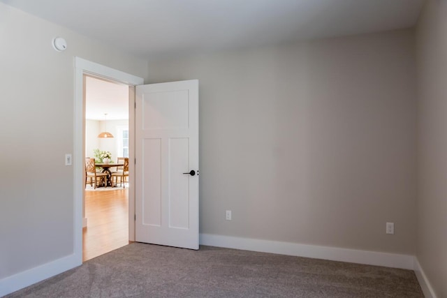 empty room featuring baseboards and carpet floors